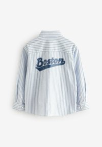 Gyerek gombos ing világoskék és fehér csíkokkal. Figyelemre méltó nagy „Boston” grafika a hátsó részen. Hosszú ujjak gombos mandzsettával.