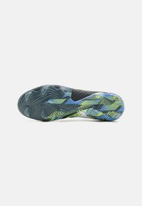 La suola della scarpa presenta una gomma testurizzata blu e verde con un motivo ondulato, progettata per garantire trazione. L'intersuola è nera e ha un design strutturato.