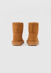 Bruna mockalädersankelbootar med en mjuk textur, rund tå och gummisula. Har sömnadsdetaljer och en medelhög design.