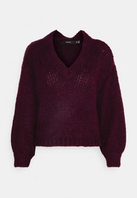 Burgundy stickad tröja med v-ringning, långa ärmar och ribbad nederdel. Texturerad tyg med små öppningar genom hela tröjan.