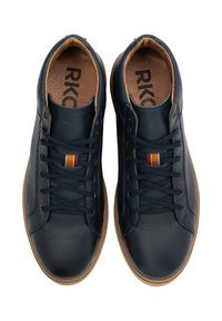 Baskets en cuir bleu marine avec une texture lisse, dotées de lacets beiges, d'une semelle intérieure beige et d'un petit accent multicolore près des lacets.