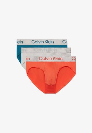 Drie paar Calvin Klein boxer shorts in teal, grijs en oranje. Elk paar heeft een zachte riem met de merknaam in contrasterende kleuren.