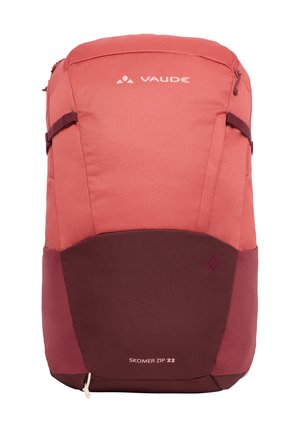 Roter und burgunderfarbener VAUDE Skomer Zip 22 Rucksack, hergestellt aus strukturiertem Stoff, mit einem Reißverschlussoberteil, Seitentaschen und Logodetail.
