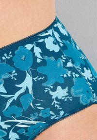Teal blomstermönstrade bikiniunderbyxor gjorda av mjuk, stretchig klädsel; har en delikat vågig kant längs midjebandet.