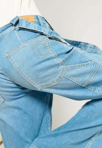 Lichtblauwe denim jeans met een slim fit, voorzien van meerdere zakken en contrasterende gele stiksels. Leren label op de tailleband.