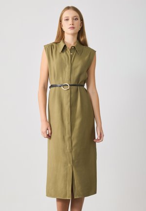 Olive green, sleeveless dress with a collar, front button closure, and a black belt featuring a circular buckle, finishing just above the knee.