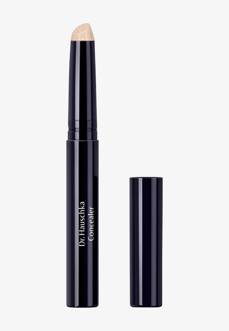 Crayon correcteur noir à twist avec une pointe crème beige et un capuchon noir assorti placés à côté sur un fond blanc.