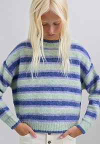 Suéter a rayas en verde, azul y lavanda, hecho de un material suave y esponjoso. Presenta un cuello alto y un dobladillo y puños de canalé.