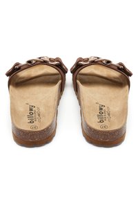 Sandales en suède marron avec des doubles brides, semelle intérieure texturée et une semelle en liège épaisse. Présente un logo en relief sur la semelle intérieure.