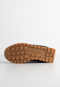 Semelle de chaussure avec profil en caoutchouc marron présentant des motifs d'étoile et de carré, marqué "Pepe Jeans London" au centre.