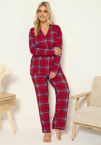 Röd och blå rutigt pyjamaset tillverkat av mjukt tyg, bestående av en knapp-up skjorta och matchande byxor med elastisk midja.