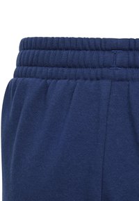 Navy blue sweatpants featuring an elastic waistband with a ribbed texture and gathered fabric at the sides for a relaxed fit.