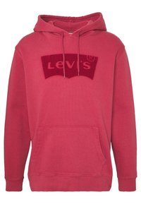 Červená bavlněná mikina s kapucí na šňůrku, přední kengurská kapsa a vyšívané logo Levi's tmavší červenou barvou na hrudi. Hladká textura.