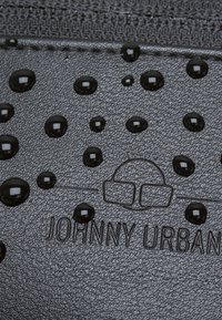 Schwarze, strukturierte Geldbörse mit glänzenden schwarzen Tropfen und eingraviertem "JOHNNY URBAN"-Logo. Schlankes Design mit wasserabweisender Beschichtung.