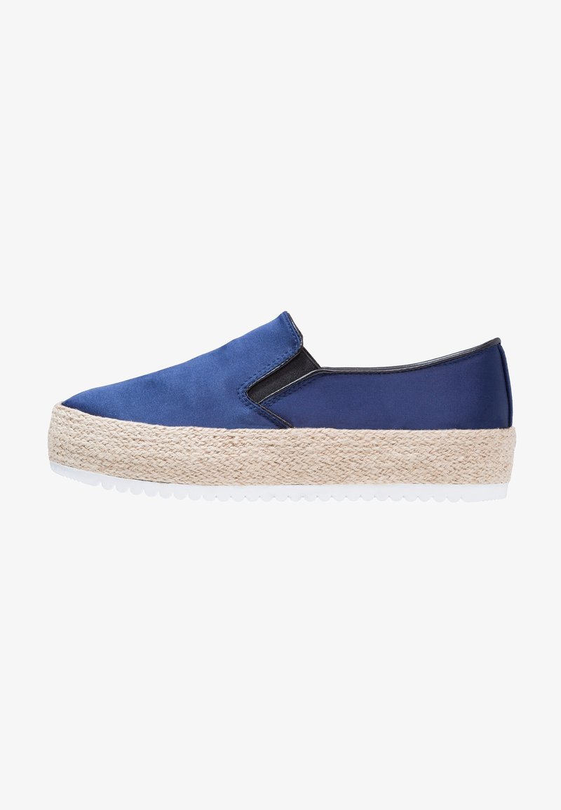 Chaussure à enfiler bleue en tissu doux avec une semelle intermédiaire en corde naturelle et une semelle extérieure en caoutchouc blanc, équipée de côtés élastiques pour un enfilage facile.