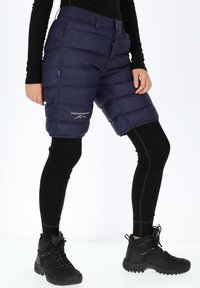 Shorts puffy navy con vita elasticizzata, tasche con zip e testo del logo. Indossati sopra leggings neri e abbinati a robusti stivali neri.