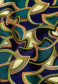Musterstoff mit wirbelnden Formen in Türkis, Marineblau, Grün und Orange. Das Material hat eine glatte Textur und ein lebendiges, farbenfrohes Design.