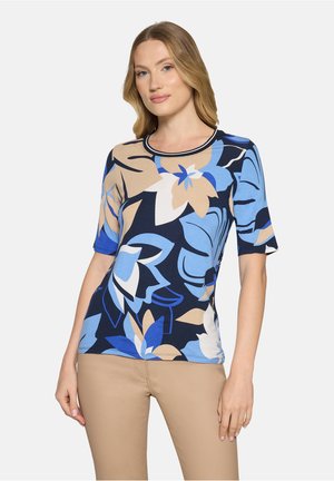 T-shirt à manches courtes bleu marine orné de grands motifs floraux en bleu et beige, avec un col rond bordé d'une finition contrastante.