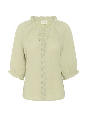 Svetlozelená blúzka vyrobená z textúrovanej látky. Má volánový výstrih, detaily na viazanie a dekoratívne šitie na prednej strane. Puffové rukávy.