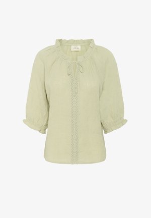Blouse vert clair en tissu texturé. Présente un col à volants, un détail à nouer et une couture décorative sur le devant. Manches bouffantes.