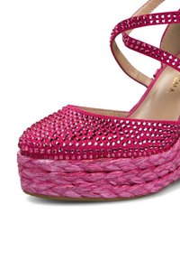 Chaussure à plateforme en daim rose avec des embellissements en strass sur le bout et des lanières croisées ; présente une semelle en corde rose tressée.