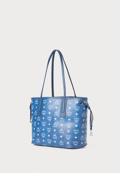 Niebieska torba tote MCM z teksturowanej skóry, ozdobiona powtarzającym się wzorem logo i podwójnymi uchwytami do noszenia.