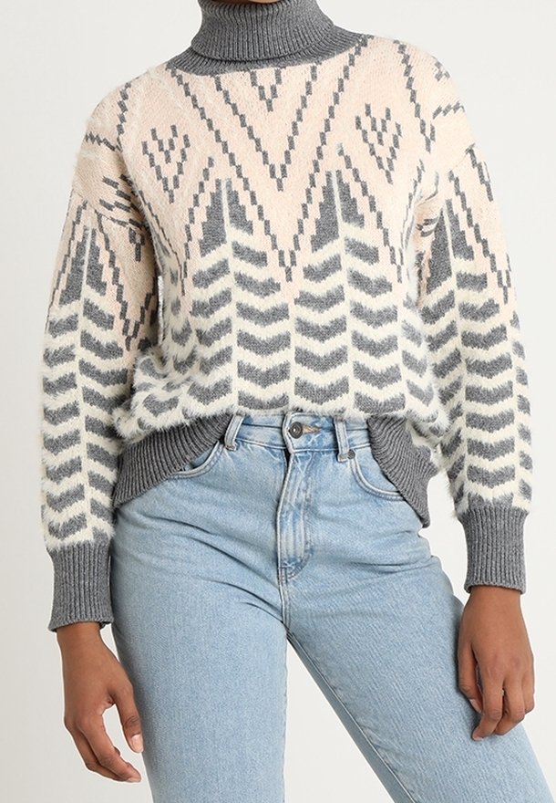 Stickad tröja med hög krage, geometriska mönster i kräm, grått och rosa. Ärmarna är ribbade, vilket ger textur och struktur.