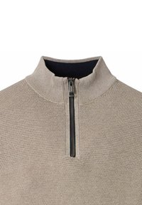 Beige strukturierter Strickpullover mit geripptem hohen Kragen und schwarzem Halbreißverschluss, Nahaufnahme des oberen Brust- und Kragenbereichs.