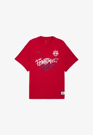 Czerwona bawełniana koszulka z okrągłym dekoltem. Posiada biało-niebieski nadruk z napisem "FUTBOL JUTRO" oraz logo na piersi. Krótkie rękawy.