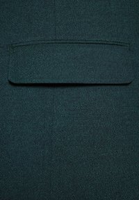 Ciemnozielony materiał o subtelnej teksturze, z pojedynczą kieszonką na górze i gładką powierzchnią z diagonalnym wzorem tkaniny.