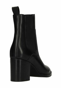 Stivale alla caviglia in pelle nera con pannelli elastici sui lati, linguetta sul tallone e tacco spesso.