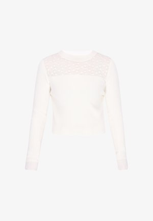 Fehér hosszú ujjú bordázott felső áttetsző virágos csipkés panellel a felső mellkason és a vállakon, kerek nyakkivágással.