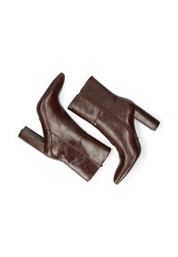 Botas de tobillo de cuero marrón con punta afilada y tacón grueso. Cuentan con una cremallera lateral y una textura suave con detalles de costura mínimos.