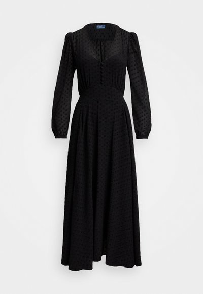 Μαύρο φόρεμα με μακριά μανίκια που διαθέτει βαθύ V-λαιμό, υφή με ανυψωμένα σημεία, καλή εφαρμογή στη μέση και ρέον σκirta. Κουμπιά κατά μήκος του μπροστινού μέρους.