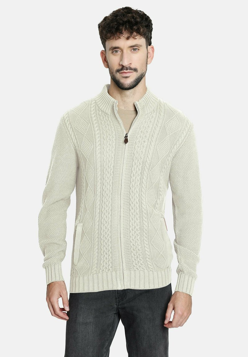 Suéter ligero color beige claro con textura de punto trenzado, puños y dobladillo acanalados, y dos bolsillos frontales. Apropiado para uso casual.