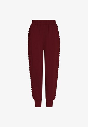 Bordinių spalvų sportinės kelnės su bangelėmis šonuose, elastine juosmens juosta ir siaurėjantys rankogaliai. Minkšta medžiaga suteikia komfortą ir laisvą prigludimą.