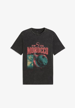 Čierne tričko s krátkym rukávom s nápisom „2026 MOROCCO“, logom Puma, ikonami revúceho leva a tigra a grafikou horiacej futbalovej lopty na prednej strane.