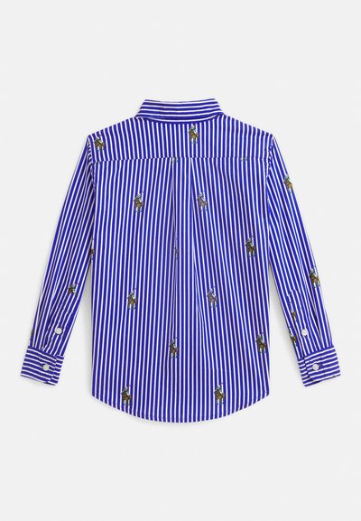 Mėlyna ir balta vertikaliai dryžuota ilgomis rankovėmis marškiniai su tolygiai išdėstytais siuvinėtiems polo žaidėjų motyvais ant audinio.