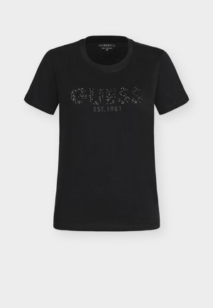 Crna majica kratkih rukava s okruglim izrezom, tekst "GUESS EST. 1981" od svjetlucavih kamenčića preko prsa.