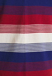 Gestreifter Strickstoff mit kräftigen roten, weißen und blauen horizontalen Bändern, die in unterschiedlichen Breiten angeordnet sind und eine weiche Textur aufweisen.