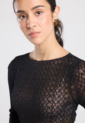 Schwarzes Spitzenoberteil mit figurbetontem Schnitt, Rundhalsausschnitt und langen Ärmeln, das ein strukturiertes Muster und halbtransparenten Stoff zeigt.