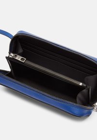 Portefeuille en cuir bleu avec fermeture éclair, doté d'un intérieur noir, de plusieurs emplacements pour cartes et d'un compartiment zippé pour la monnaie.