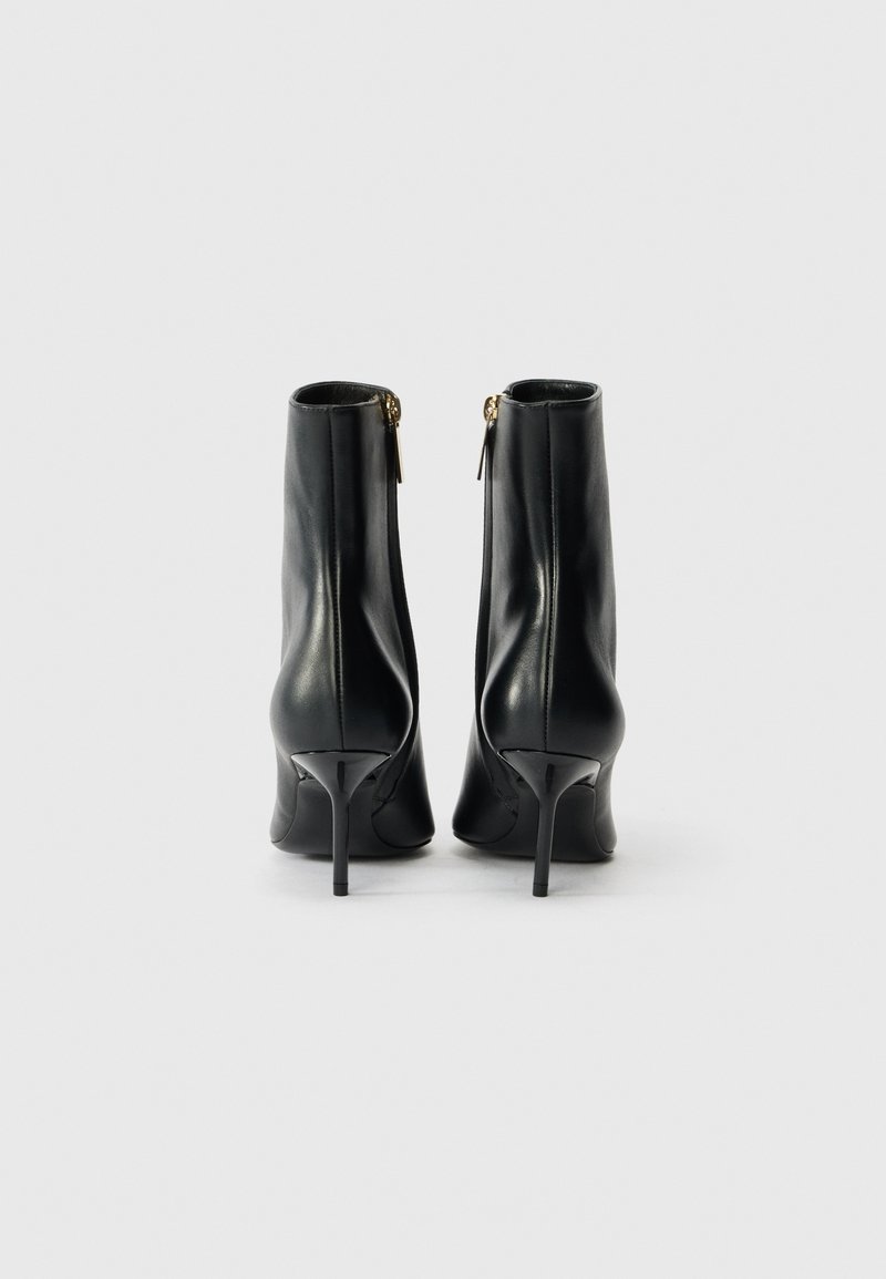 Svarta läderankelstövlar med en stilren design, spetsig tå och stilettklack. Har en sidodragkedja och slät textur.