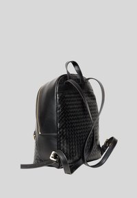 Zaino in pelle nera con una texture intrecciata su un lato, tasca con zip e due spallacci regolabili. Accenti in metallo dorato.