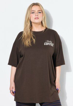 Camiseta larga marrón de tejido suave, con el texto "Friday COFFEE" en impresión blanca. Mangas cortas y un corte holgado.