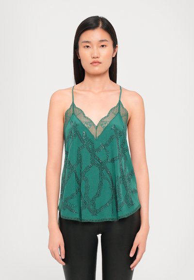 Camisole en dentelle verte avec un décolleté à volants, arborant un motif en chaîne et des bretelles fines et réglables, fabriquée en tissu léger.
