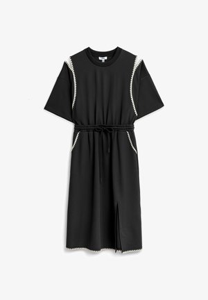 Robe noire longueur genou avec manches courtes, taille élastique avec cordon de serrage, poches latérales, fente devant, et bordure blanche en zigzag.