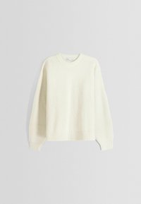 Kremowy sweter z prążkowanego dzianiny z długimi rękawami i okrągłym dekoltem, zaprezentowany na jasnym tle.