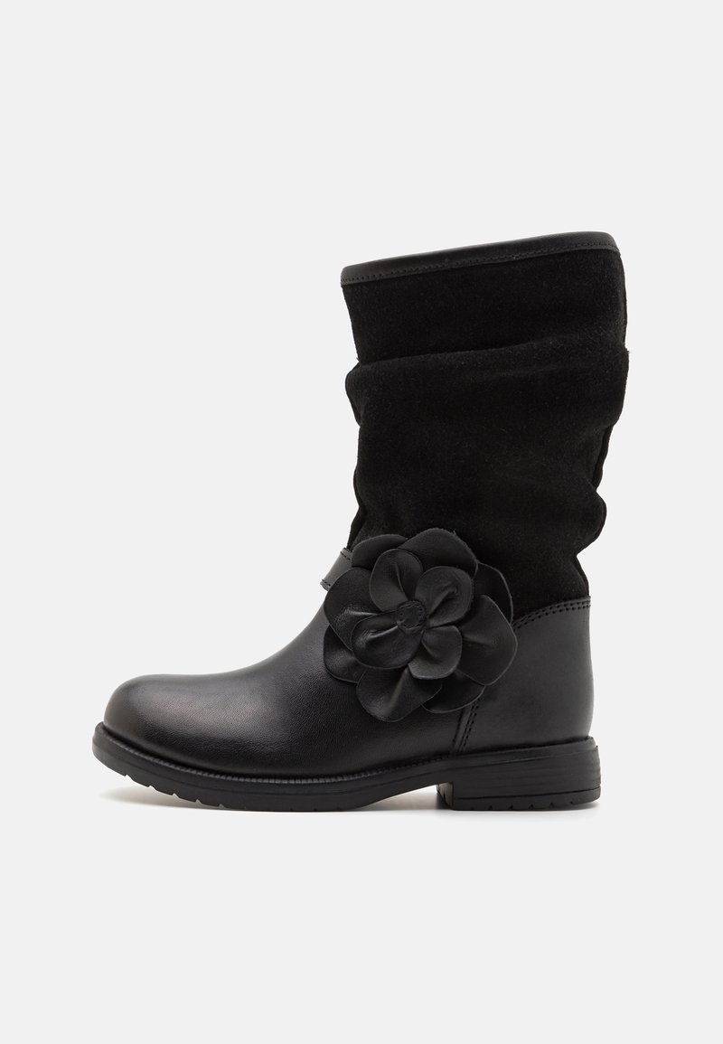 Botas negras de tobillo que combinan cuero y ante, con un diseño holgado y un prominente acento floral en el lado exterior.