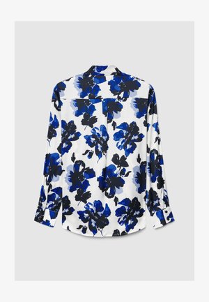 Florale Bluse in Weiß mit blauen und schwarzen Blumenmustern. Lange Ärmel, Manschetten mit Knöpfen und eine Falte am Rücken. Glatter, leichter Stoff.